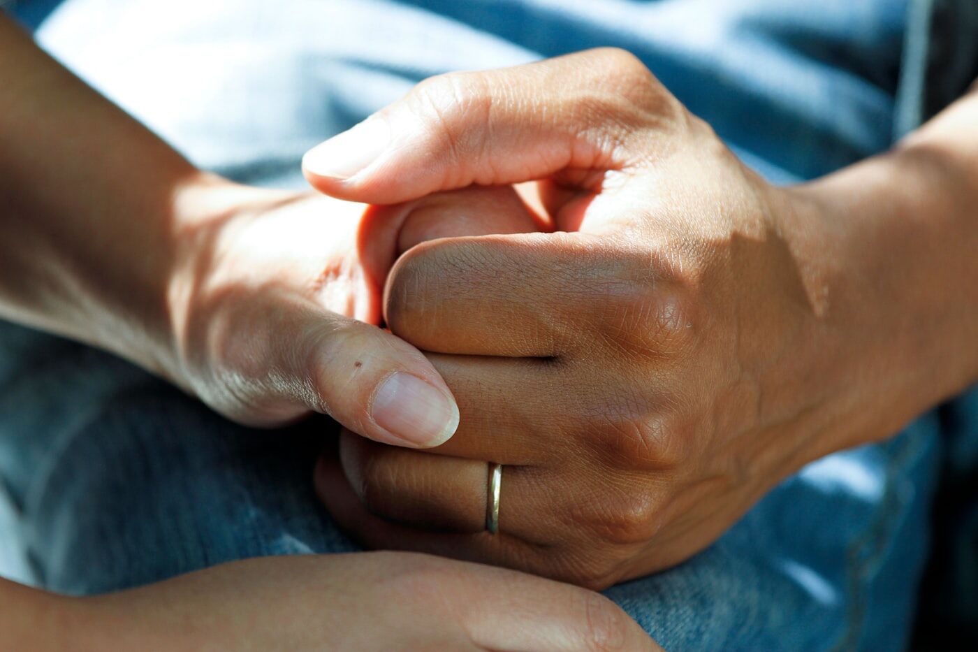 Two people holding hands in a gesture of care and support