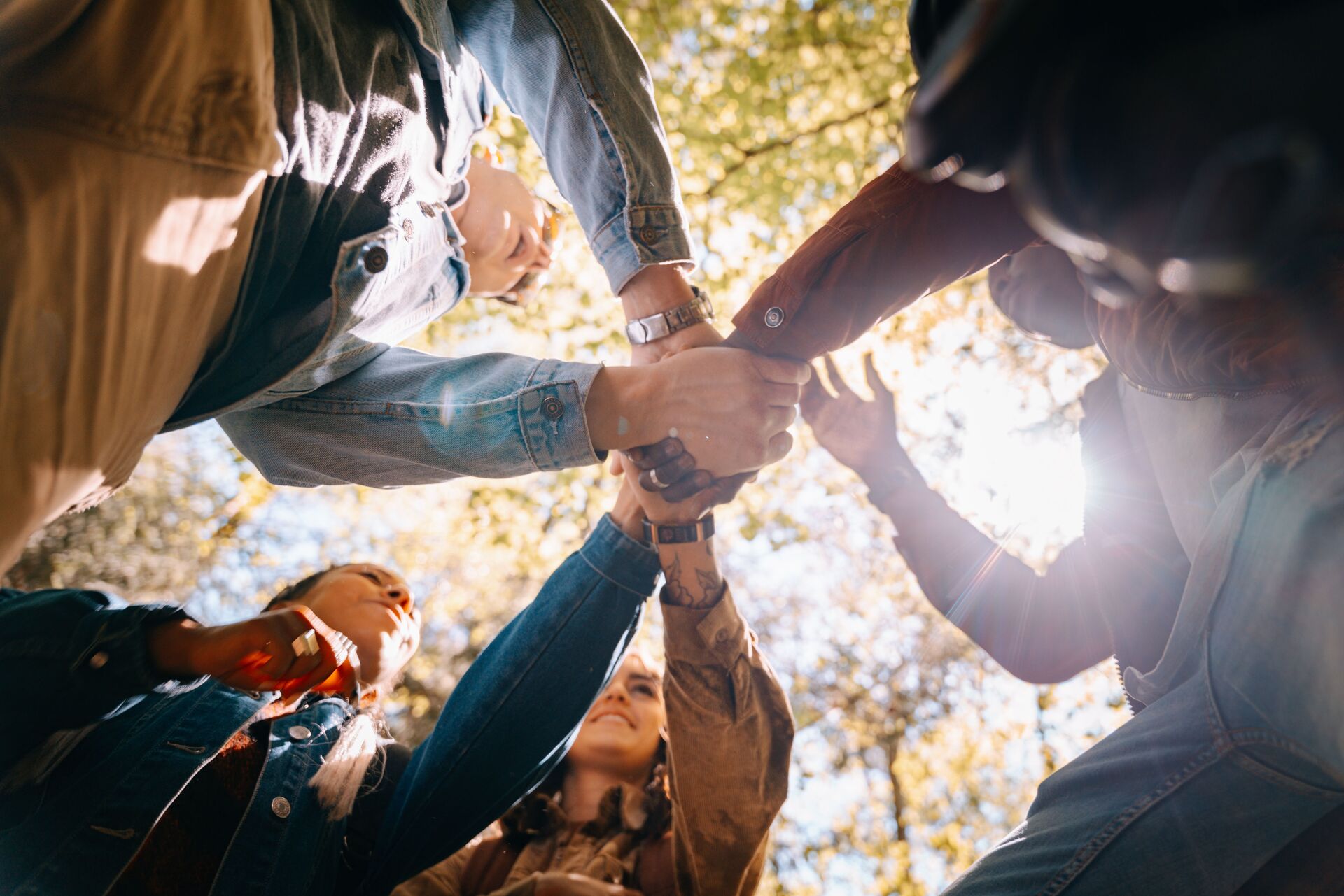 People joining hands in a circle, a gesture of trust and community